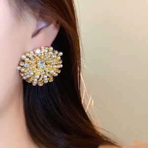 Close-up of French vintage gold-tone floral stud earrings with pearls and rhinestones