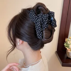 Detail van een stijlvolle haarklem met bloemrijke strik in een elegante haarknot