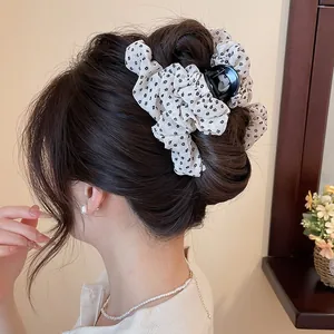 Close-up van een elegante bloemen stoffen haarklem op een stijlvol knotkapsel