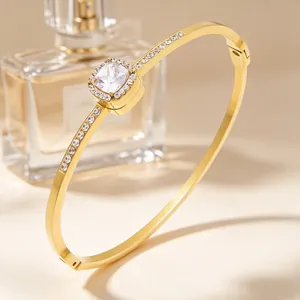 Detailed view of 18K gold plated titanium steel bangle with square rhinestone halo.