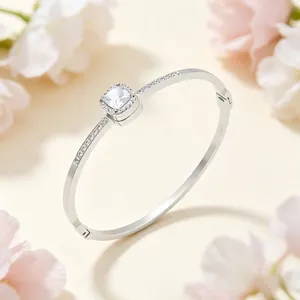 Detailed close-up of a square CZ centerpiece on a silver-toned titanium steel bangle.