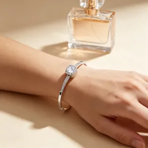 Detailed view of silver square halo rhinestone bangle worn on a model's wrist
