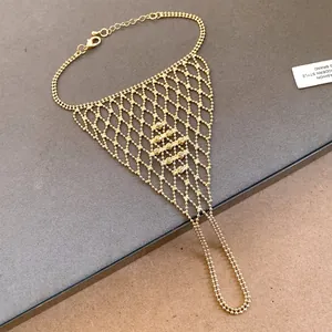 Detailed view of a gold beaded mesh slave bracelet with a delicate finger loop and clasp.