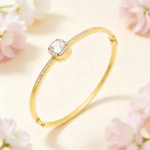 Macro view of gold plated bangle with a stunning square halo rhinestone centerpiece.