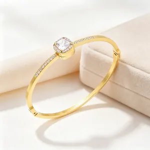 Close-up detail of square halo titanium steel bangle with 18K gold plating and crystals