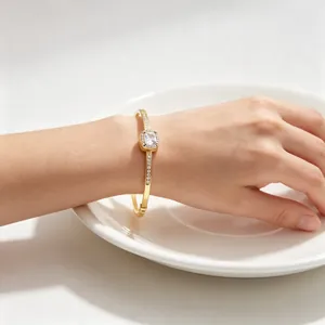 Close-up of elegant 18K gold plated titanium steel bangle with square zircon center
