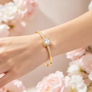 Close-up detail of a square halo rhinestone gold-plated bangle on a woman's wrist