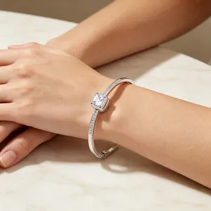 Detailed view of silver-colored titanium steel square halo crystal bangle on woman's wrist