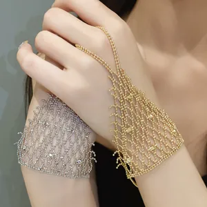 Detail of elegant gold and silver hollow mesh ring-bracelet hand chain on model hands