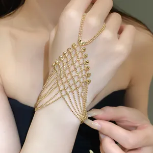 Detailed macro view of a gold hollow tassel ring bracelet integrated hand chain