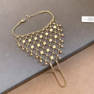 Intricate detail of a golden mesh finger bracelet with faceted beads and tassel dangles