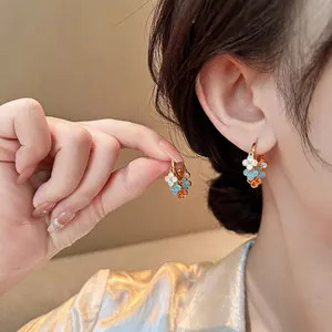 Gros plan de créoles rétro luxueuses avec des breloques fleurs en zircone colorée