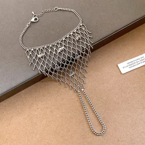 Detailed macro view of silver hollow mesh tassel ring-bracelet integrated hand chain.