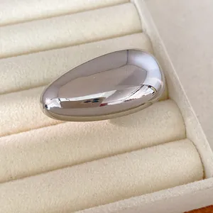 Detailed close-up showing the mirror finish of a minimalist silver oval metallic stud earring