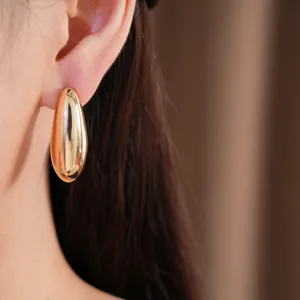 Elegant gold-toned oval drop earrings featuring a smooth and polished metallic finish