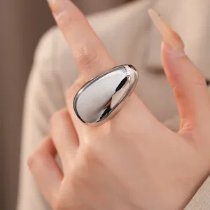 Detailed macro shot of a chunky polished silver oval ring on a model's hand