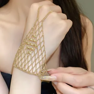 Detailed view of an elegant gold-toned beaded mesh slave bracelet with ring integration.