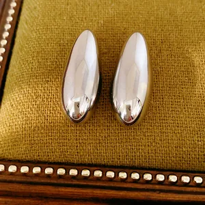 Close-up of oval polished silver stud earrings with high-shine metallic finish