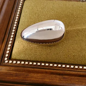 Detailed close-up showing the high-polished smooth surface of a silver oval stud earring