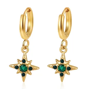 Detail van elegante gouden roestvrijstalen sterren oorbellen met groene zirkoniasteentjes.