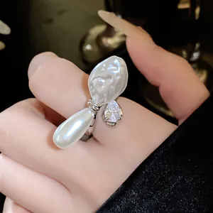Elegante Nahaufnahme eines einzigartigen Barockperlenrings mit Zirkonia am Finger