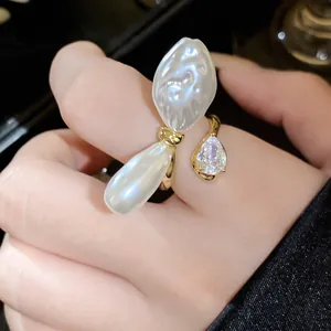 Detailansicht eines eleganten offenen Rings mit gefalteten Perlen und einem Tropfen-Zirkon.