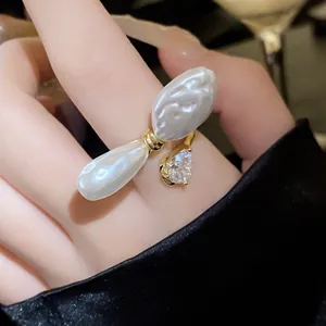 Detailansicht eines goldfarbenen offenen Rings mit Barockperlen und Zirkonia-Tropfen