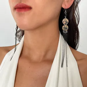 Détail rapproché de boucles d'oreilles rétro en acrylique à pompons portées par un mannequin