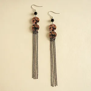 Détail de boucles d'oreilles vintage en acrylique avec imprimé bambou et longs glands