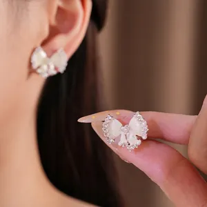 Elegante witte emaille strikoorbellen versierd met parels en zirkoon kristallen