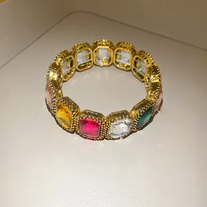 Close-up of a vintage-style stretch bracelet featuring multi-colored oval gemstones