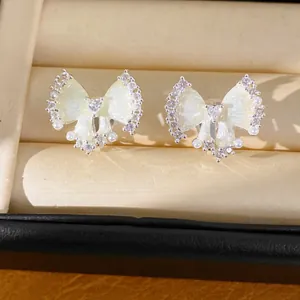 Detail van elegante zirkoon strik oorklemmen met parels en olie-afwerking