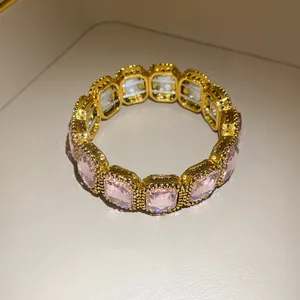 Close-up of vintage gold elastic bracelet with pale pink rectangular crystals
