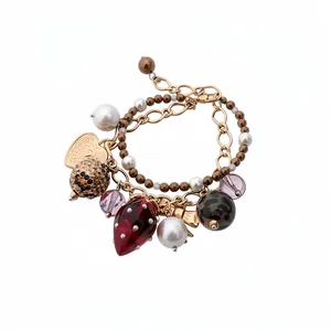 Zweilagiges Perlenarmband mit Erdbeere, Schleife und Herzanhängern in Vintage-Gold