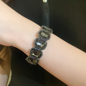 Detailed close-up of a vintage elastic bracelet with dark oval crystals on a model arm