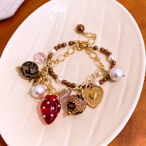 Detailansicht eines vintage doppelreihigen Armbands mit Erdbeer Herz Anhängern und Perlen