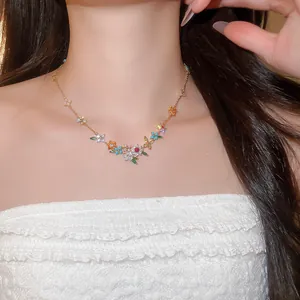 Close-up detail of 18k gold plated necklace with colorful zircon flowers worn on neck.