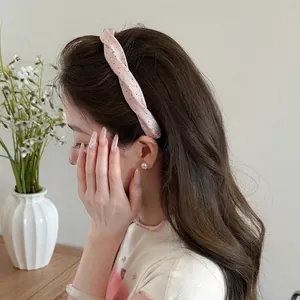 Detalle de primer plano de una diadema de tela retorcida con lunares rosas en mujer