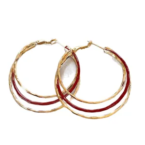 Grote drielaagse gouden oorringen met elegante donkerrode emaille afwerking voor dames.