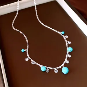 Elegant lace-style silver necklace with turquoise beads and clear zircon drops.
