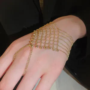 Close-up of gold beaded mesh hand back chain ring bracelet combo with hollow tassel design