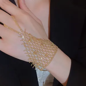 Close-up of golden hollow mesh ring-bracelet integrated chain with fringe detail