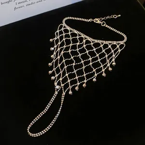 Close-up detail of the intricate hollow mesh design and tassel beads on the hand chain