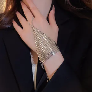 Detail view of a golden sequin mesh slave bracelet with integrated finger ring