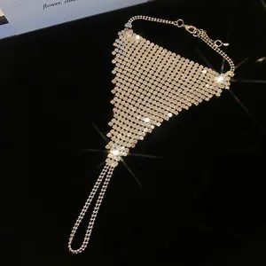 Sparkling silver metallic mesh hand chain with integrated ring on black velvet background