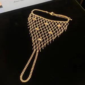 Detail view of gold hollow mesh tassel ring-bracelet integrated hand harness jewelry