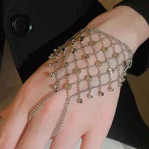 Detailed view of an elegant silver hollow tassel ring bracelet integrated chain on hand.