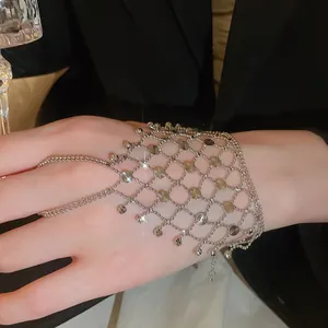 Detailed macro shot of a silver mesh hand harness bracelet with hollow tassel rings.