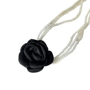 Elegante mehrsträngige Perlenkette mit einer großen schwarzen Stoff-Kamelienblüte