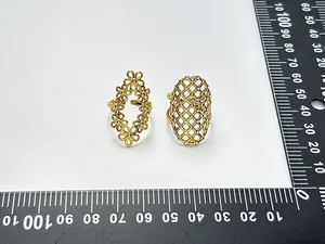 Detailansicht von zwei vergoldeten Ringen mit Blumen- und Gittermuster und Maßstab